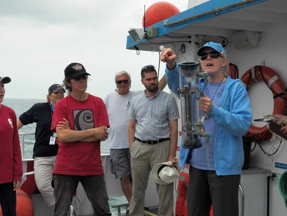 Science instructor Ann Hesselsweet demonstrating a Van Dorn bottle used for collecting water samples during a cruise at Hammond, Indiana.